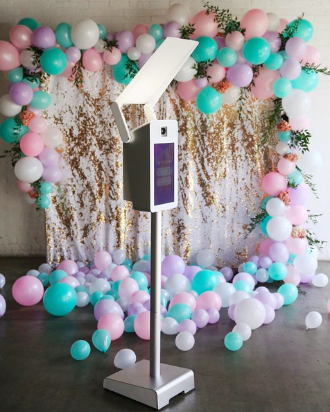 Open air photo booth with balloon garland backdrop
